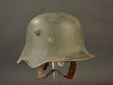 an old helmet on a stand on a gray background