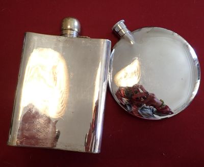 a silver flask with a picture of a woman on it