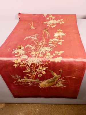 a red table runner with birds and flowers on it