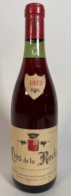 une vieille bouteille de vin posée sur une table blanche