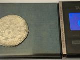 a silver coin sitting on top of a scale on a table