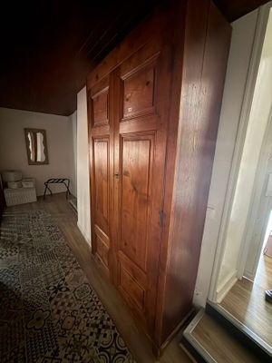 a wooden door in the hallway leading to a bed