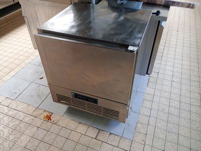a stainless steel oven sitting on a tiled floor in a kitchen
