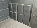 many speakers that are stacked up in the corner of a room