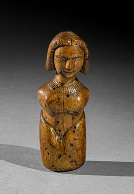 une vieille figurine en bois représentant une femme tenant un bébé dans ses bras