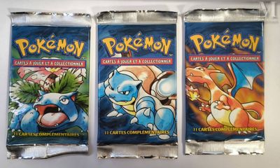 three packs of pokemon trading cards on a white surface