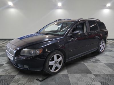 a picture of a black volvo wagon parked in a garage