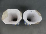 two white vases with blue and yellow designs on them