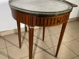 a small table with a marble top on a tiled floor
