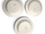 three white plates are sitting next to each other on a white surface
