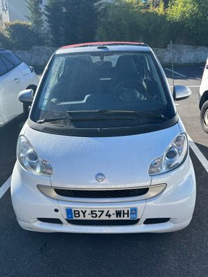 une petite voiture blanche garée dans un parking