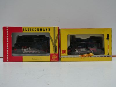 two boxes of toy trains sitting on a white surface