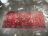 un tapis rouge posé sur un sol en béton, près d'un mur