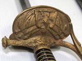a gold colored sword with a black and gold handle