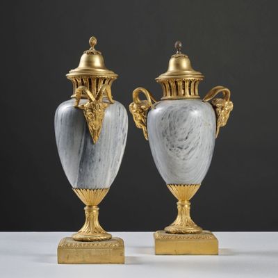 une paire de vases anciens posés sur une table blanche