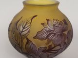 a yellow vase with a flower design on it