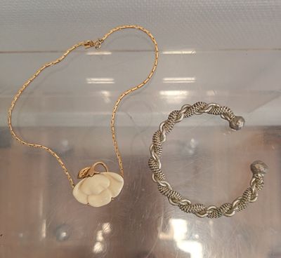 two necklaces and a bracelet on display in a case