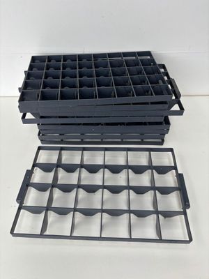 two black plastic trays are stacked on top of each other on a white surface