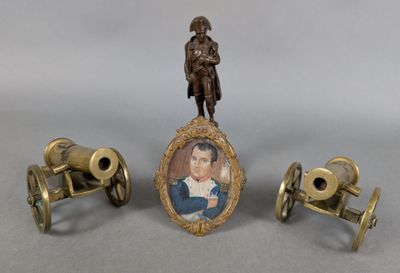 three miniature objects including a miniature cannon, a miniature picture frame and a miniature picture of a man