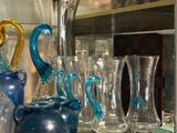 many glass vases on a glass shelf in a glass case