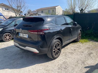 l'arrière d'une voiture noire garée sur un parking près d'une clôture