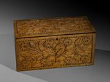 une vieille boîte en bois sculptée posée sur une table