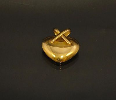 a gold heart shaped ashtray on a black surface