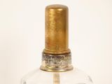 a glass bottle with a gold cap on a white background