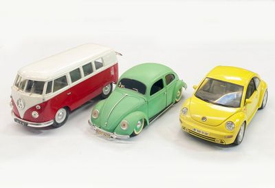 three toy cars sitting next to each other on a white surface