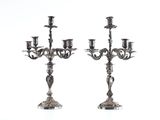 pair of silver plated candelabs with candles on each of them