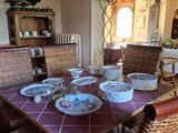 une table sur laquelle sont posées des assiettes et des bols, dans la salle à manger