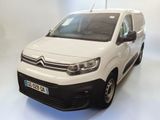 La camionnette blanche est garée sur le sol blanc de la pièce.