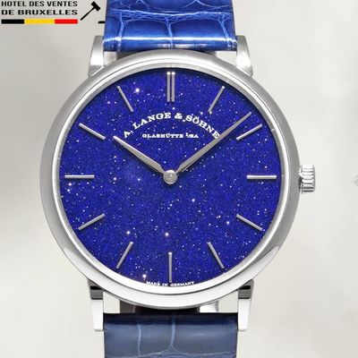 a close up of a wrist watch with a blue leather strap