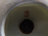 a close up view of a white vase with a monogram on it