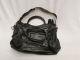 black leather handbag with zippers and handles on a white background