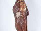 an old statue of a woman in a brown dress and a hat