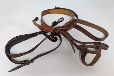three belts that are tied together on a white surface