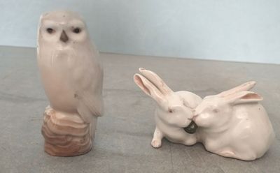 deux figurines d'animaux et un oiseau posés sur une table