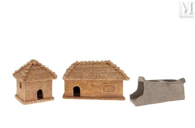 two small clay houses are sitting next to each other on a white surface