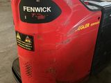 a red forklift parked in a garage with a sign on it