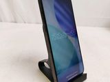a close up of a cell phone on a stand on a bed