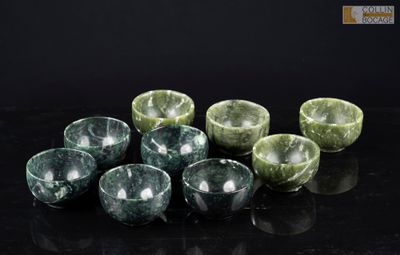 six bols en marbre vert posés sur une table noire