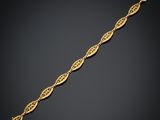 un bracelet en or orné d'un motif de feuilles