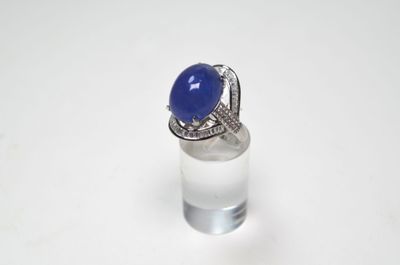 bague sertie d'une pierre bleue et de diamants sur un fond blanc