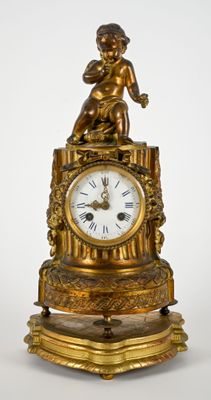 une horloge en or surmontée d'une statue