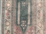 an antique rug with a green background and a pink border