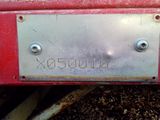 a close up of a metal plate on a red truck
