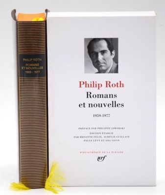 a book with a picture of a man on it next to a yellow feather