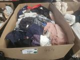 a cardboard box filled with clothes and other items