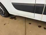 a dirty white truck parked on the side of the road